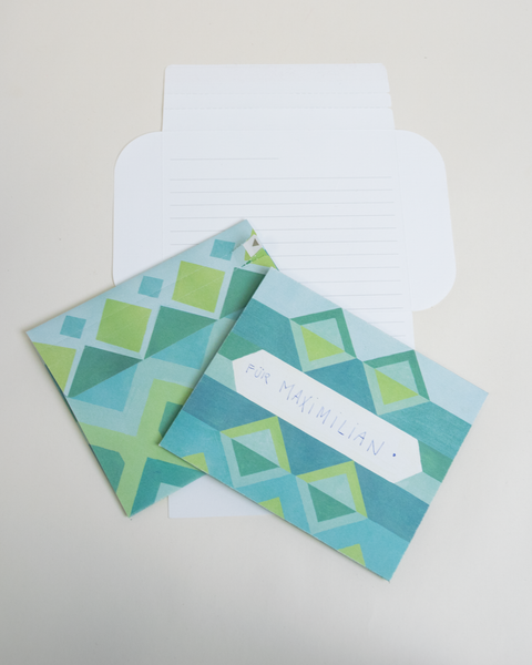 Three blue jacquard design letterfolds showing the front, back, and interior views of the design