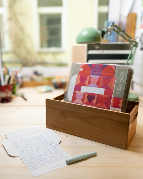 Three hearts design letterfolds and an open letterfold arranged in a stylish stationery desk setting.