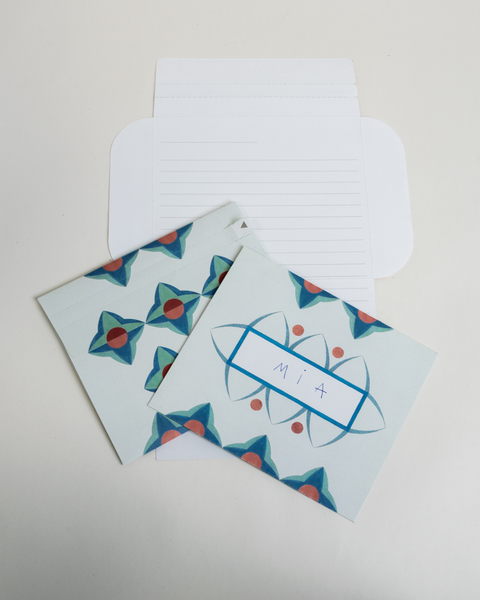 Three turquoise floral letterfolds showing the front, back, and interior views of the design