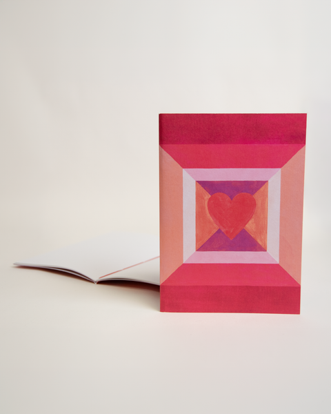A5 notebook featuring a colorful heart design, shown from the front and open to reveal its interior.
