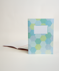 A5 notebook featuring a colorful hexagon design, shown from the front and open to reveal its interior.