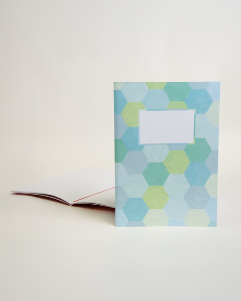 A5 notebook featuring a colorful hexagon design, shown from the front and open to reveal its interior.