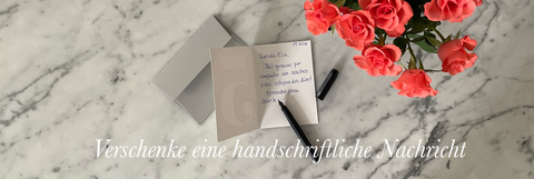 Offene Grußkarte mit handgeschriebener Nachricht auf grauem Umschlag, verziert mit Blumen – handgefertigte Öko-Papierwaren aus Berlin.