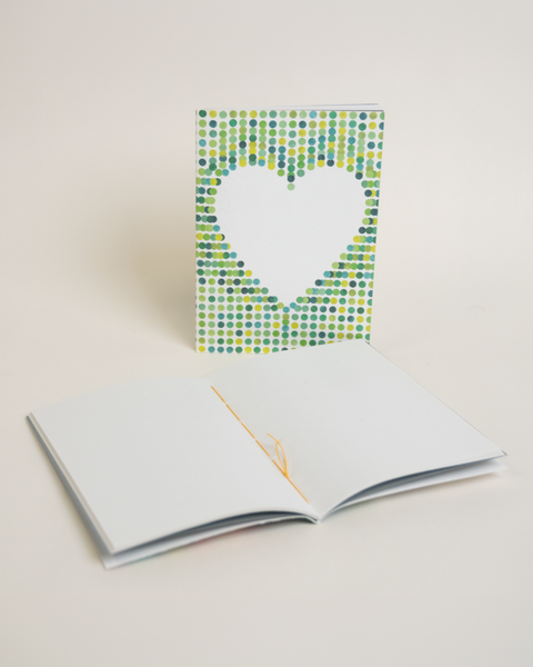 Eco-friendly notebook Lovely on green dots, angled view, DIN A6 recycled paper cover, handmade in Berlin