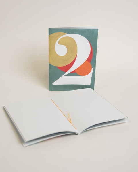 Eco-friendly notebook number 2, angled view, DIN A6 recycled paper cover, handmade in Berlin