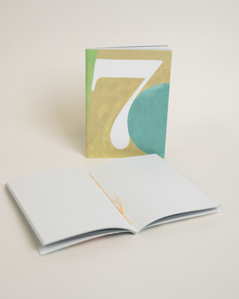 Eco-friendly notebook number 7, angled view, DIN A6 recycled paper cover, handmade in Berlin